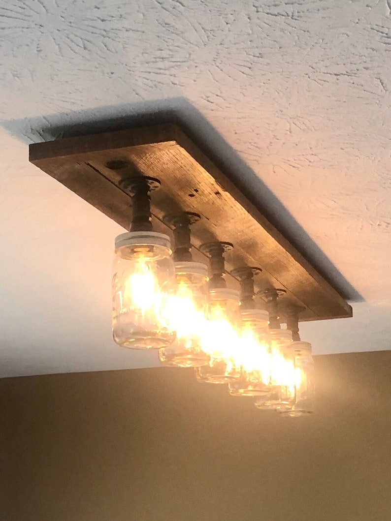 Pu&ograve; includere: Un lampadario rustico in legno per soffitto con sei luci in barattolo di muratore. Il lampadario &egrave; realizzato in legno riciclato e ha un design a tubo.