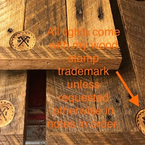 Pu&ograve; includere: Primo piano di una superficie in legno con un timbro marrone che dice "W & E" con due martelli incrociati. Il testo "All lights come with my wood stamp trademark unless requested otherwise in notes in order." &egrave; visibile nell'immagine.