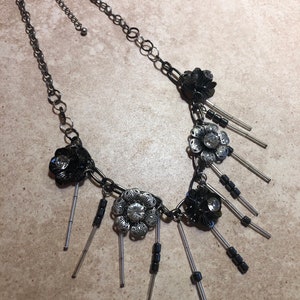 Metallic flower necklace with rhinestone accents and silver bars