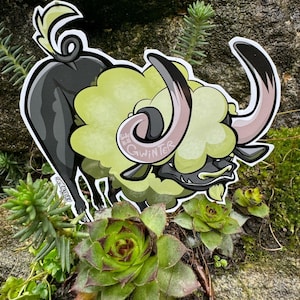 Peut inclure: Un mouton de dessin animé vert et noir avec une longue corne recourbée. Le mouton est debout sur un lit de plantes vertes. Le texte "Side Hill GwinTer" est écrit sur le côté du mouton.