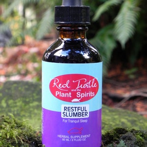 May include: A glass bottle with a dropper top and a purple and blue label that reads "Red Turtle and the Plant Spirits Restful Slumber For Tranquil Sleep Herbal Supplement 60 ml / 2 fluid oz."