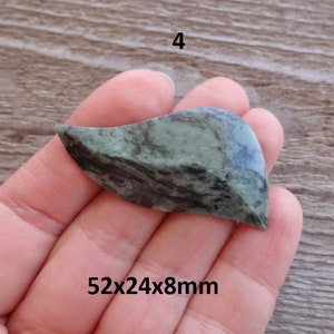 Puede incluir: Una piedra verde y negra con forma de hoja, que mide 52x24x8mm.