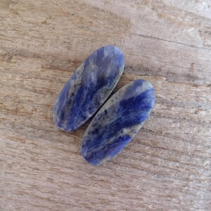 K&ouml;nnte beinhalten: Zwei ovale, blaue und wei&szlig;e Lapislazuli-Steine mit Marmorierung.