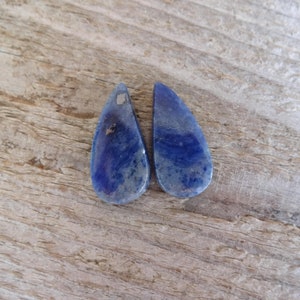 K&ouml;nnte beinhalten: Zwei tropfenf&ouml;rmige blaue Lapislazuli-Steine mit wei&szlig;en Adern.