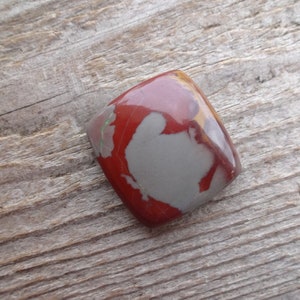May include: A red, gray, and brown jasper cabochon with a square shape.