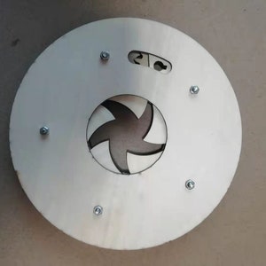 Peut inclure: Un disque en bois rond blanc avec une découpe en forme d'étoile à cinq branches au centre. Le disque a six vis argentées autour du bord.