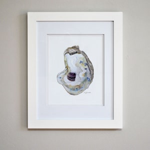 May include: A framed watercolor painting of an oyster shell with a purple interior. The shell is painted in shades of blue, green, and brown. The painting is signed by the artist.