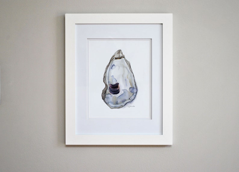 May include: A framed watercolor painting of a single oyster shell with a blue and white interior. The shell is painted in a realistic style and has a subtle texture.