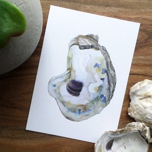 May include: A watercolor painting of an oyster shell with a purple interior. The shell is painted in shades of blue, green, and brown.
