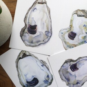 May include: Four watercolor paintings of oyster shells. Each shell is painted in shades of white, gray, and blue with a purple interior. The shells are arranged in a grid pattern on a white background.