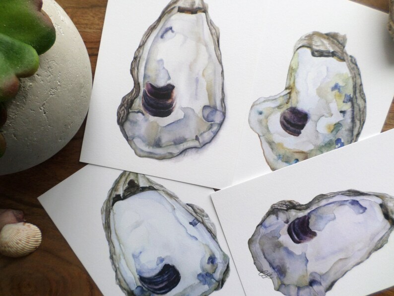 May include: Four watercolor paintings of oyster shells. Each shell is painted in shades of white, gray, and blue with a purple interior. The shells are arranged in a grid pattern on a white background.