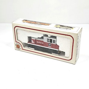 May include: A red and white Burlington Northern HO scale model train locomotive in its original box. The box is white with a red border and the train is nestled in white foam. The locomotive has the number 9260 on the side.