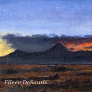 May include: A painting of a mountain range at sunset. The sky is a vibrant orange and purple, with dark clouds in the foreground. The mountains are silhouetted against the sky, and the ground is a dark brown.