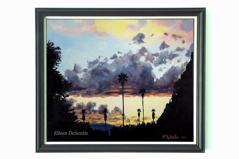 May include: A painting of a sunset with palm trees silhouetted against a cloudy sky. The sky is a mix of pink, orange, and yellow, with dark gray clouds. The palm trees are black against the bright sky. The painting is signed "Eileen DeSantis" in the lower left corner and "ED DeSantis 2015" in the lower right corner.