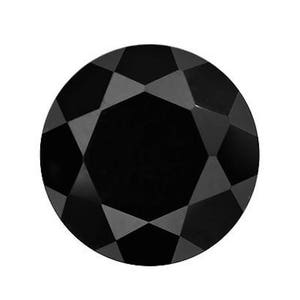 Puede incluir: Una piedra preciosa redonda negra con corte facetado.