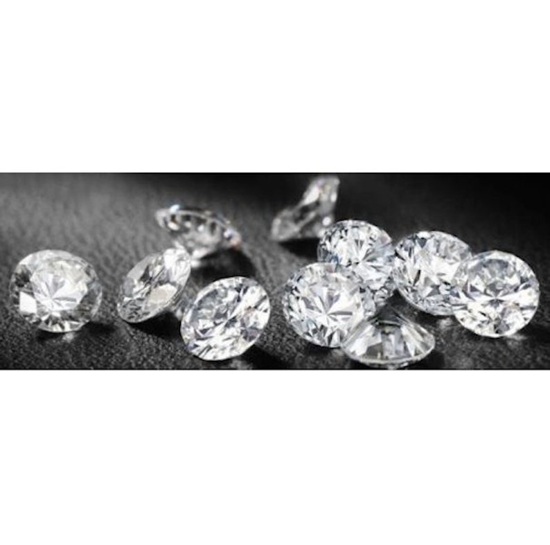 May include: A group of round, clear, sparkling diamonds on a black surface.
