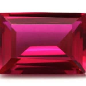 Op de afbeelding: Een dieprode rechthoekige edelsteen met een facetgeslepen vorm.
