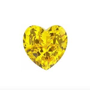 Puede incluir: Una gema de color amarillo brillante en forma de coraz&oacute;n con un corte facetado.