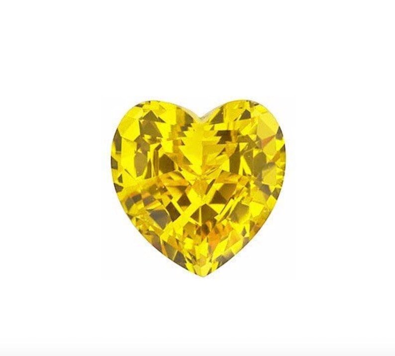 Puede incluir: Una gema de color amarillo brillante en forma de coraz&oacute;n con un corte facetado.