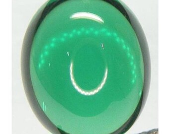 Puede incluir: Una piedra preciosa redonda y verde en cabujón con una superficie lisa y pulida.