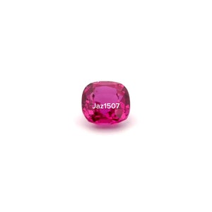 May include: A vibrant pink gemstone with a cushion cut. The gemstone is set against a white background. The text "Jaz1507" is visible in the image.