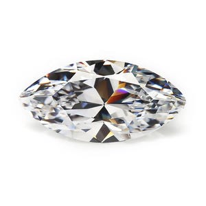 May include: A marquise-cut diamond with a brilliant, faceted surface. The gemstone is clear and colorless, reflecting light to create a sparkling effect. The elongated shape and pointed ends are prominent against the white background.