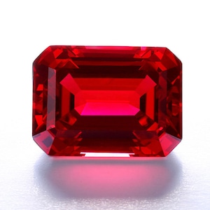 Può includere: Una pietra preziosa di colore rosso intenso con taglio rettangolare smeraldo.