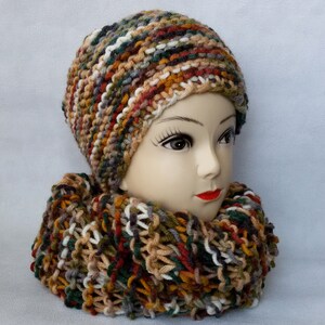 May include: A knitted hat and scarf set in a multi-colored pattern of brown, green, white, and orange.