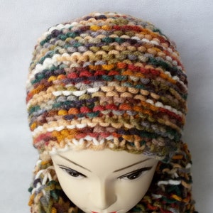 May include: A multi-colored knitted hat and scarf set with a mix of brown, orange, green, white, and gray yarn.