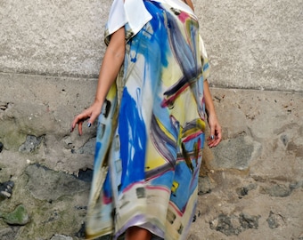 May include: A woman wearing a white and blue abstract print dress with a white collar. She is wearing white sunglasses and white heels.