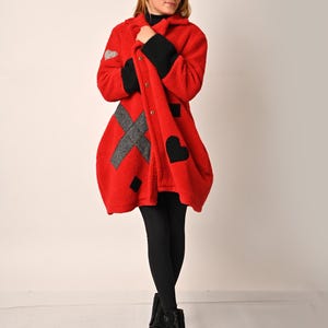 May include: A red fleece coat with black and grey geometric designs. The coat has a button closure and a collar.