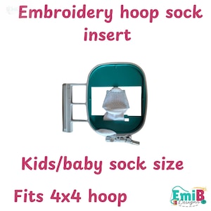 Peut inclure: Un insert de chaussette pour cerceau de broderie pour enfants et bébés. L'insert est vert d'eau et blanc, avec le texte "Embroidery hoop sock insert", "Kids/baby sock size", et "Fits 4x4 hoop". Le logo EmiB Designs est en bas à droite.