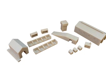 May include: A collection of miniature off-white plastic building components including a small house, two rectangular partitioned troughs, two small blocks, a tall chimney-like structure, a sloped ramp, a long rectangular building, and three small domes.