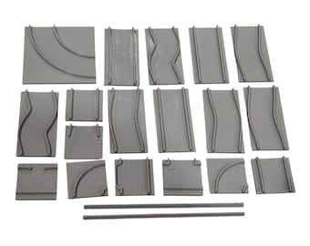 May include: A collection of gray plastic modular road tiles for tabletop gaming, featuring various straight, curved, and wavy track patterns. The set includes rectangular and square base pieces with raised road markings and two separate thin rods.