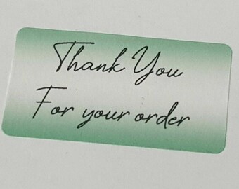Puede incluir: Una pegatina de agradecimiento verde y blanca con el texto "Thank You For your order".