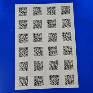 Puede incluir: Una hoja de papel blanco con 18 códigos QR en blanco y negro dispuestos en una cuadrícula.
