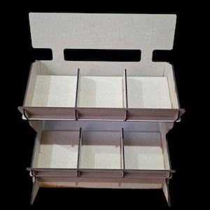 May include: A two-tiered wooden display stand with a rectangular base and a top section. The stand has multiple compartments for organizing items. The wood has a natural, light brown colour, and the background is black.