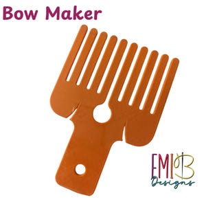 Può includere: Uno strumento arancione per creare fiocchi con un design a pettine e un manico. Il testo "Bow Maker" è in alto e il logo "EMIB Designs" in basso a destra.