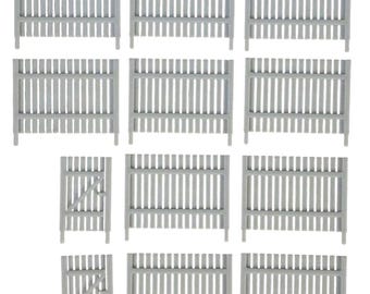 May include: A collection of twelve light gray miniature fence panels and gates. The set includes ten rectangular fence sections with vertical slats and two smaller gate sections featuring a diagonal support brace and a small latch detail.