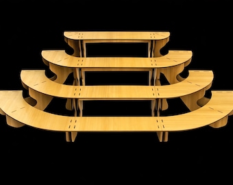 May include: A tiered wooden display stand with four curved shelves. The shelves are supported by vertical wooden supports and are arranged in a stepped configuration. The stand is made of light-coloured wood and is set against a black background.