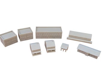 May include: A collection of eight unpainted, light beige miniature buildings for model dioramas. The set includes various architectural styles, featuring rectangular structures with flat roofs, pitched roofs, and small porch details, all rendered in a solid, matte finish.