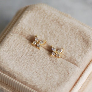 Peut inclure: Une paire de boucles d'oreilles papillon en or avec des pierres claires en forme de marquise.