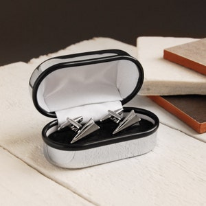 Peut inclure: Un coffret à boutons de manchette noir avec un jeu de boutons de manchette en forme d'avion en argent à l'intérieur. Les boutons de manchette sont en forme d'avion en papier.
