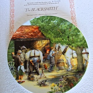 Può includere: Un piatto rotondo in ceramica con un'illustrazione colorata di un fabbro che lavora su un cavallo bianco in un fienile. Il piatto fa parte di una serie da collezione intitolata 'The Blacksmith'.