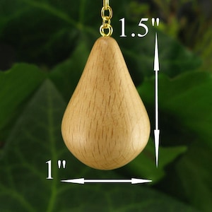 May include: A light wood pear-shaped ornament with a gold chain, measuring 1.5 inches tall and 1 inch wide.