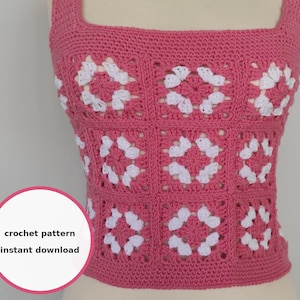 May include: A pink crochet top with a square neckline and straps. The top features a pattern of white floral designs within square panels. The text "crochet pattern instant download" is in a white circle.