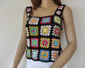May include: A black crochet top with a square pattern in various colors, including red, yellow, blue, green, and white.