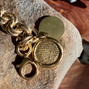 May include: Gold chain bracelet with a gold charm that reads "The ability to see the beauty in the ordinary things is a gift. Take a moment to appreciate the difference. Amen."