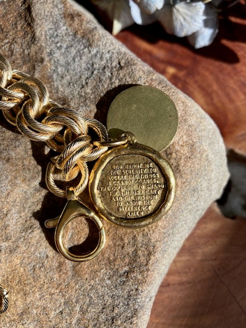 May include: Gold chain bracelet with a gold charm that reads "The ability to see the beauty in the ordinary things is a gift. Take a moment to appreciate the difference. Amen."