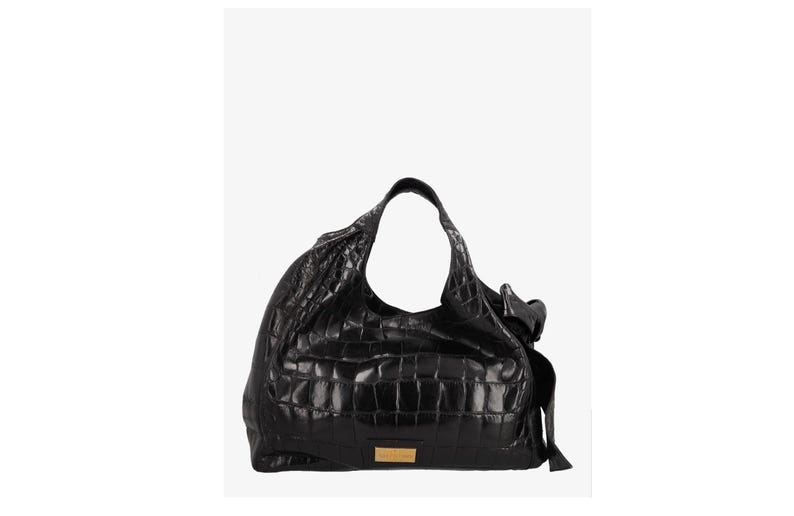 May include: Black leather shoulder bag with a crocodile skin texture. The bag has a large, open design with a single shoulder strap. A small, rectangular gold-colored plaque is on the front.